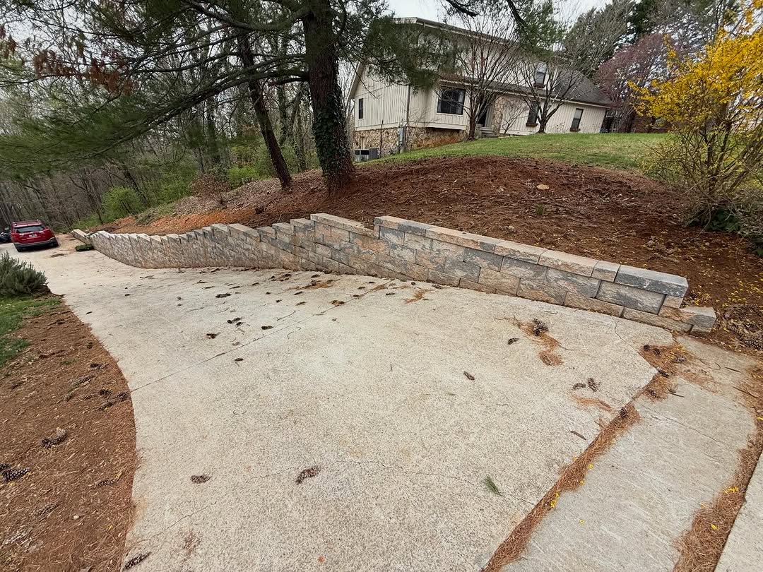 Stone retaining wall along driveway